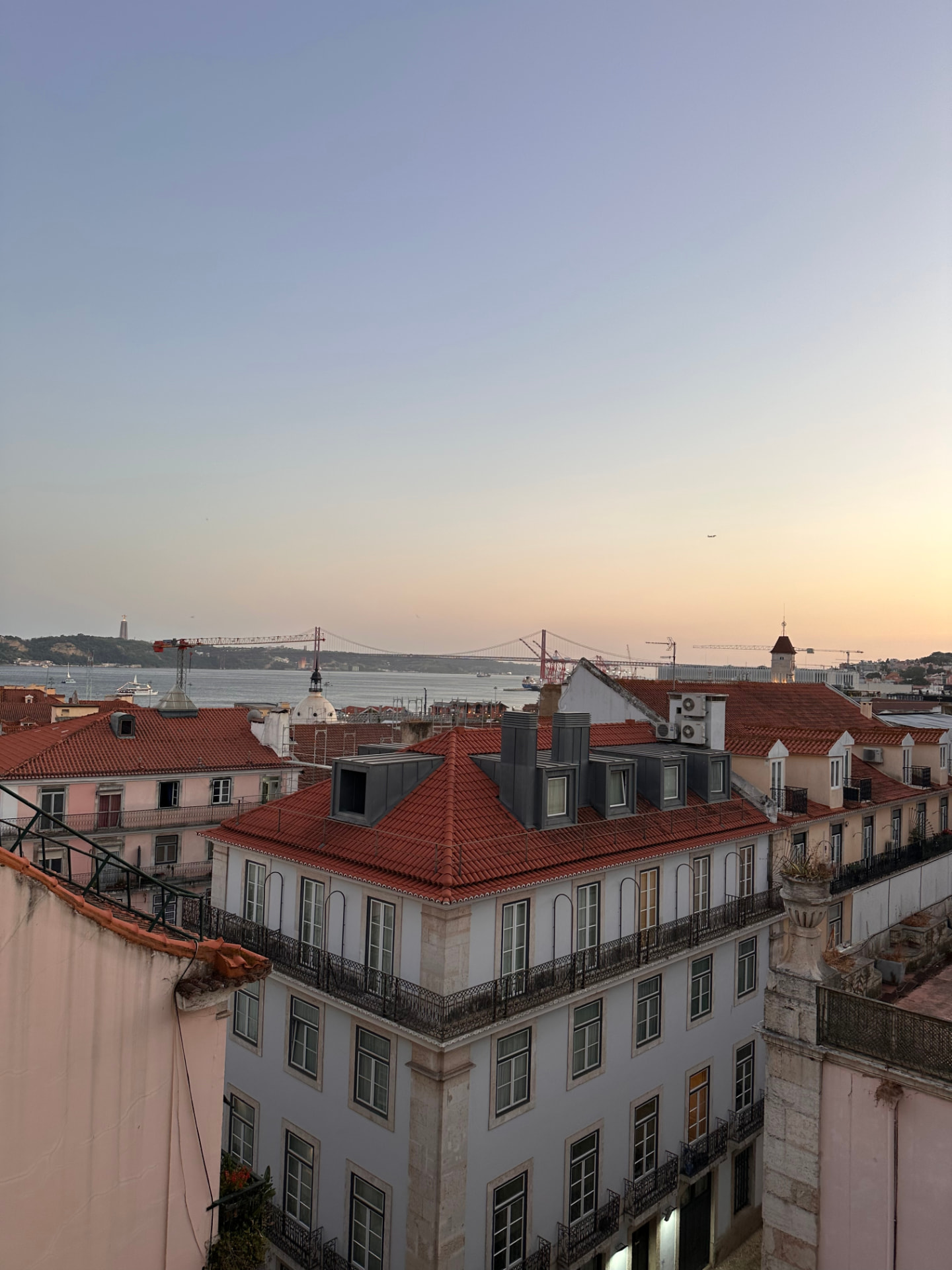 Daytime view over Lisbon rooftops, the Tejo river and the 25 de Abril bridge