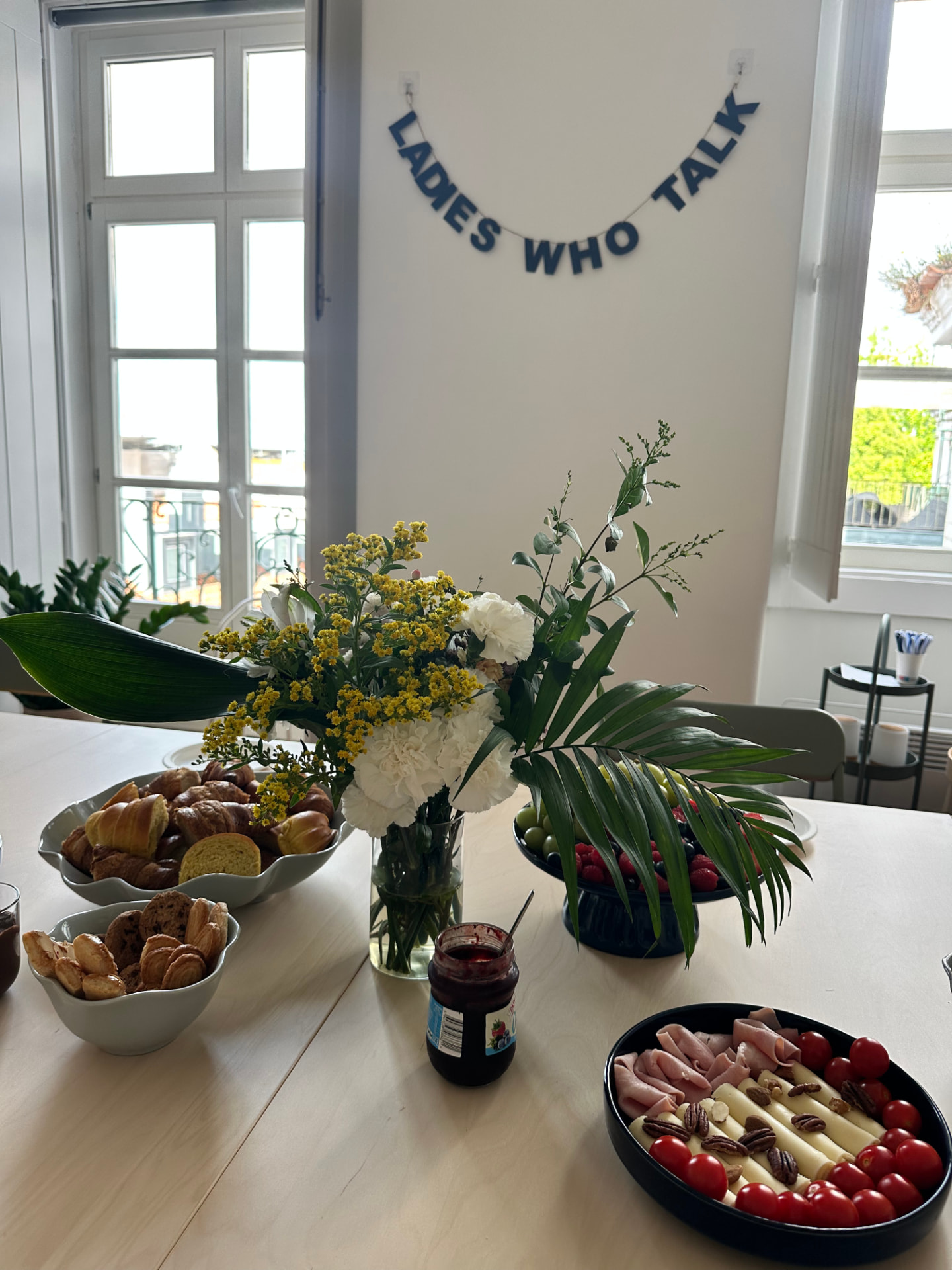 Catering set up on the table at the Hub with pastries, fruit and flowers
